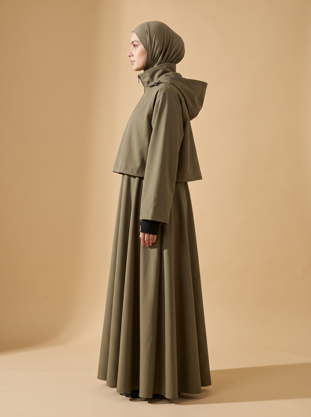 Sakina Zaytoun, veste longue à capuche coloris kaki, vue de profil