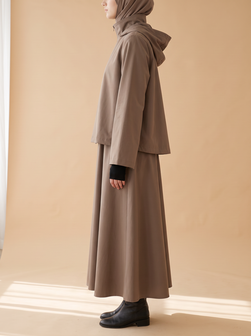 Sakina Tîn, veste longue à capuche coloris taupe, vue de profil